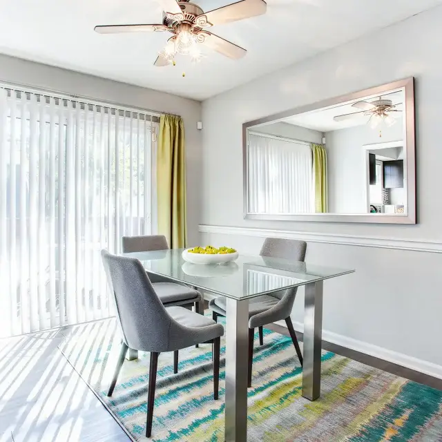 Bright dining area with glass table and sliding patio doors at Elea Apartments in Marietta, GA