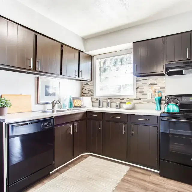 Updated apartment kitchen with dark cabinetry and modern appliances at Elea Apartments in Marietta, GA