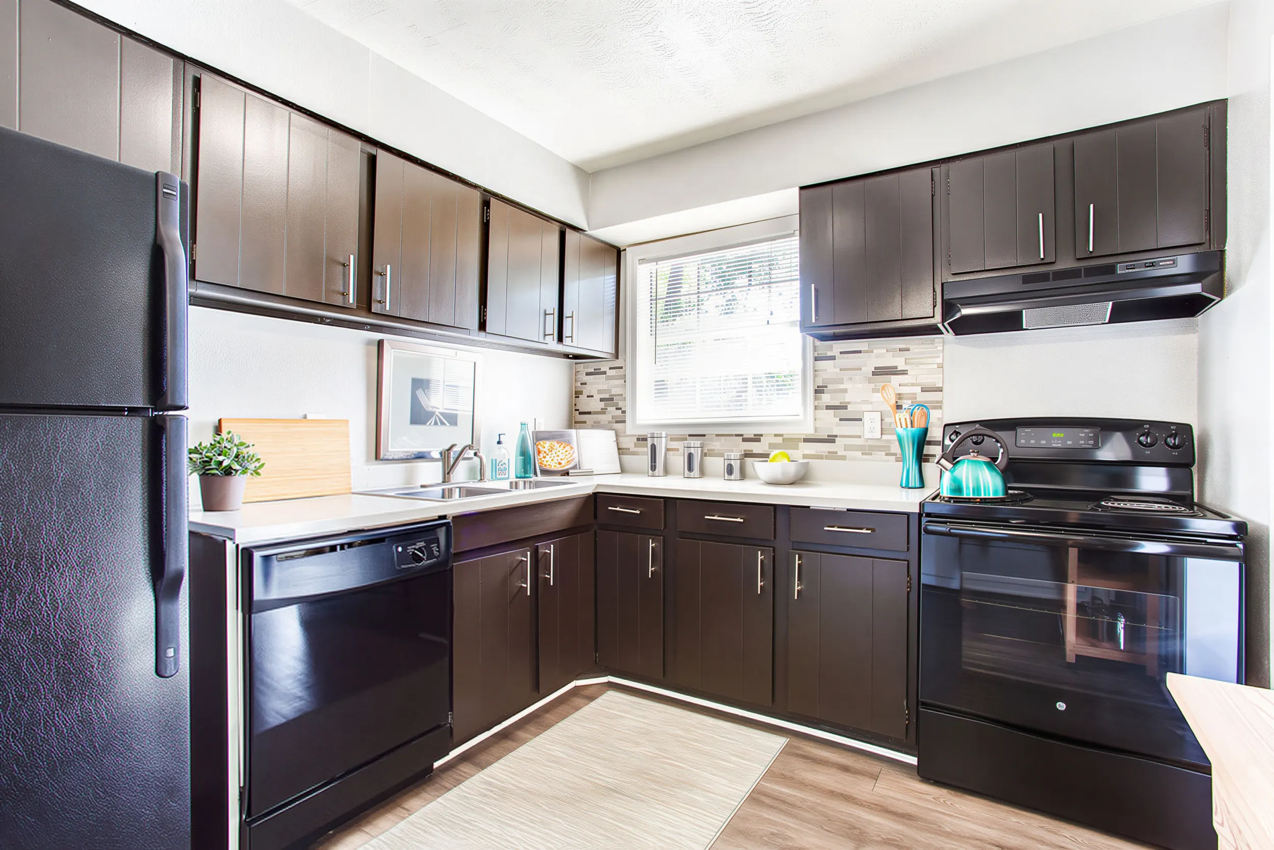 Updated apartment kitchen with dark cabinetry and modern appliances at Elea Apartments in Marietta, GA