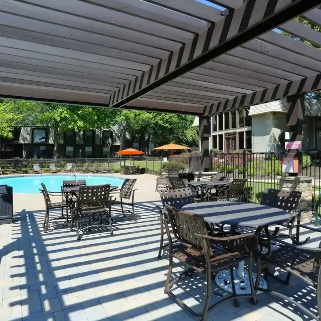 Shaded poolside seating and outdoor gathering area at Elea Apartments in Marietta, GA