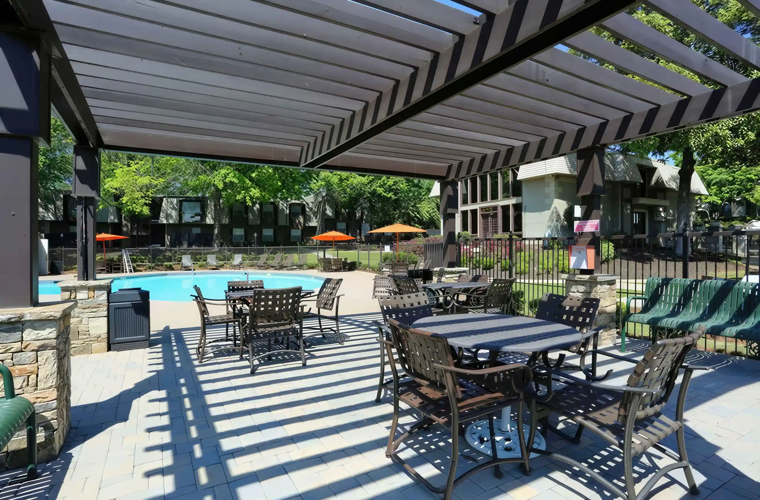 Shaded poolside seating and outdoor gathering area at Elea Apartments in Marietta, GA